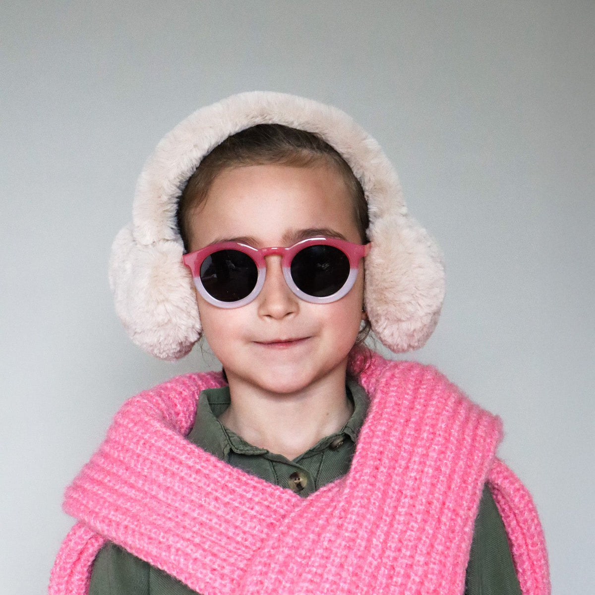 Paire de lunettes de soleil pour enfants catégorie 3, avec monture en TPEE effet transparent couleur rose et blanc. Mise en situation portée