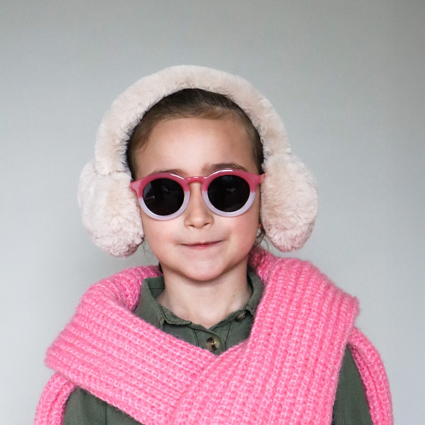 Paire de lunettes de soleil pour enfants catégorie 3, avec monture en TPEE effet transparent couleur rose et blanc. Mise en situation portée