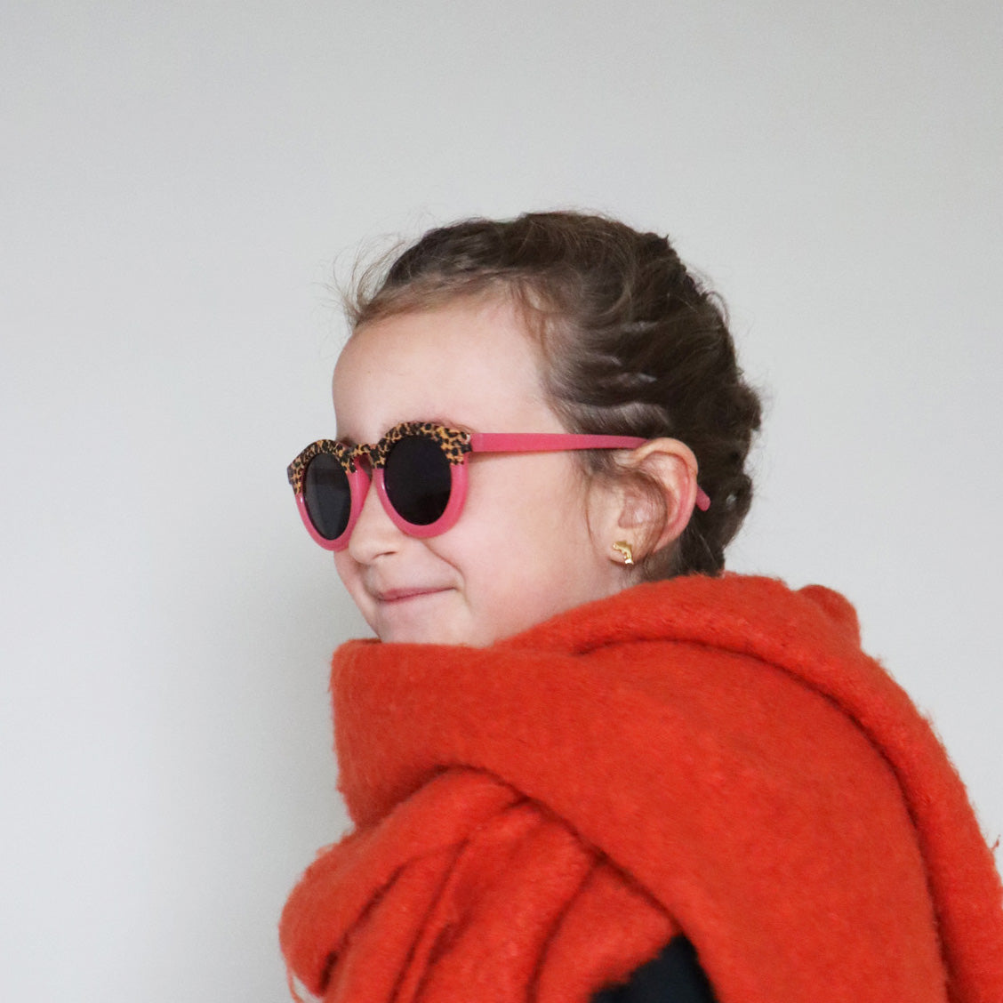 Paire de lunettes de soleil pour enfants catégorie 3, avec monture en TPEE rose avec motif léopard sur le haut. Mise en situation portée de profil